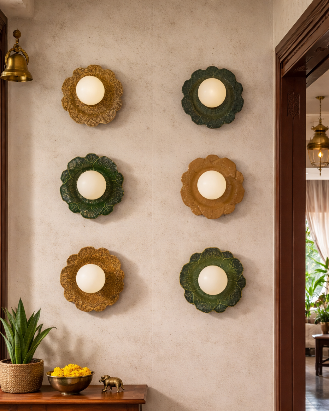 Decorative wall lights on a textured wall with a plant and small table in the foreground.
