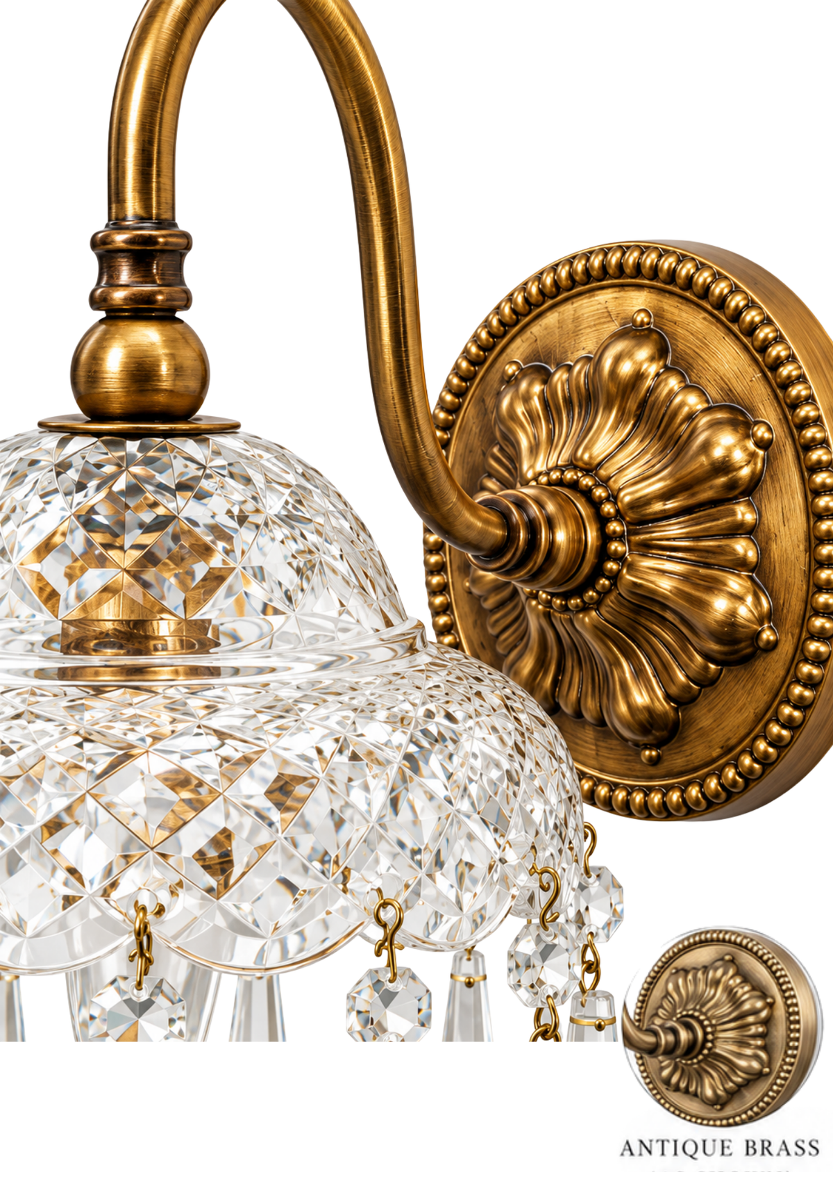 An antique brass wall sconce with a decorative floral wall mount, curved arm, clear cut crystal globe shade, hanging crystal drops, and a smaller inset showing the backplate detail on a white background.