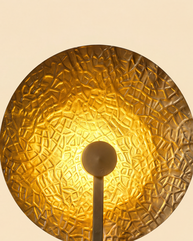 Aaranya Halo Wall Light Handcrafted Solid Brass Designer Wall Sconce | Made in India Gold textured wall sconce on a beige background