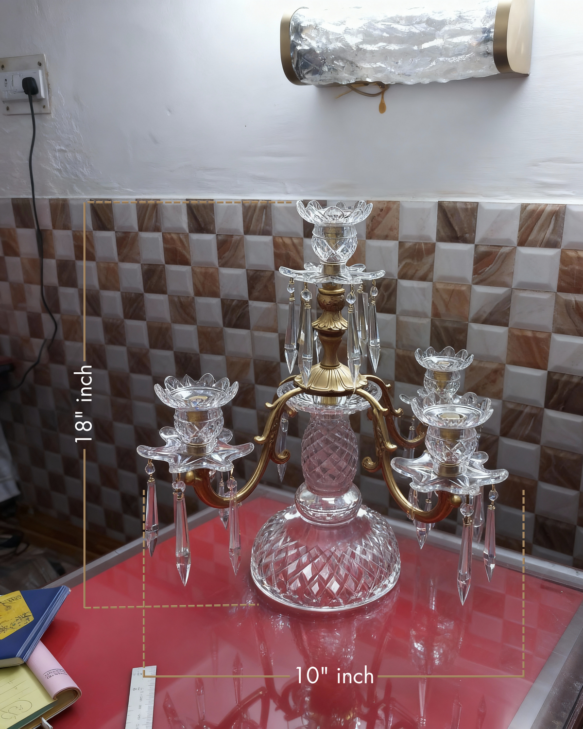 Decorative crystal candelabra on a table with a tiled wall background