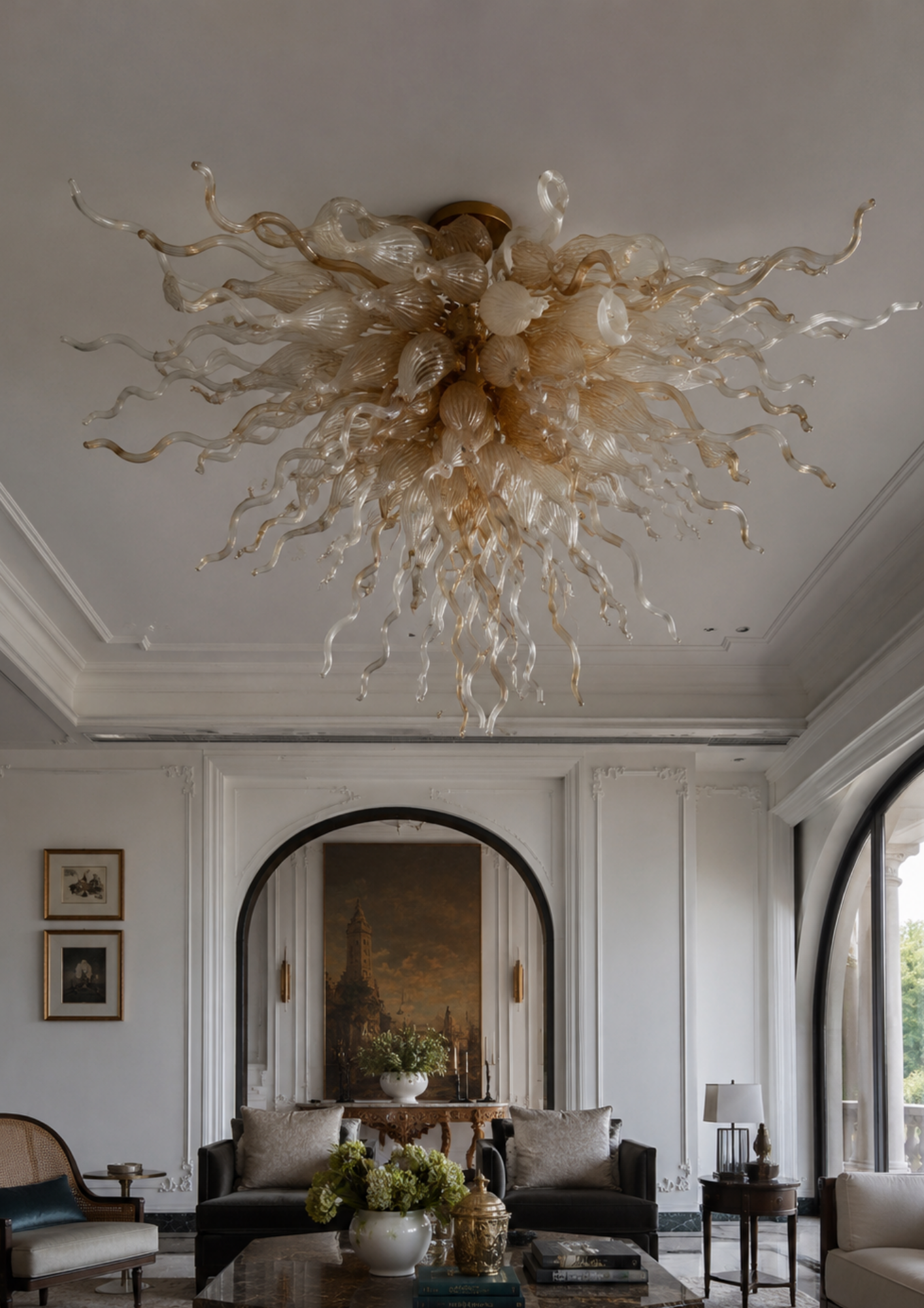 Luxurious chandelier hanging in a stylish living room with arched doorways and framed artwork.