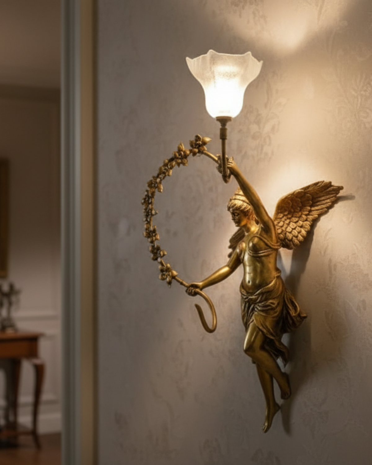 Devika Royale Celestial Wall Sconce Decorative wall sconce with angel figure and glass shade on a wall.