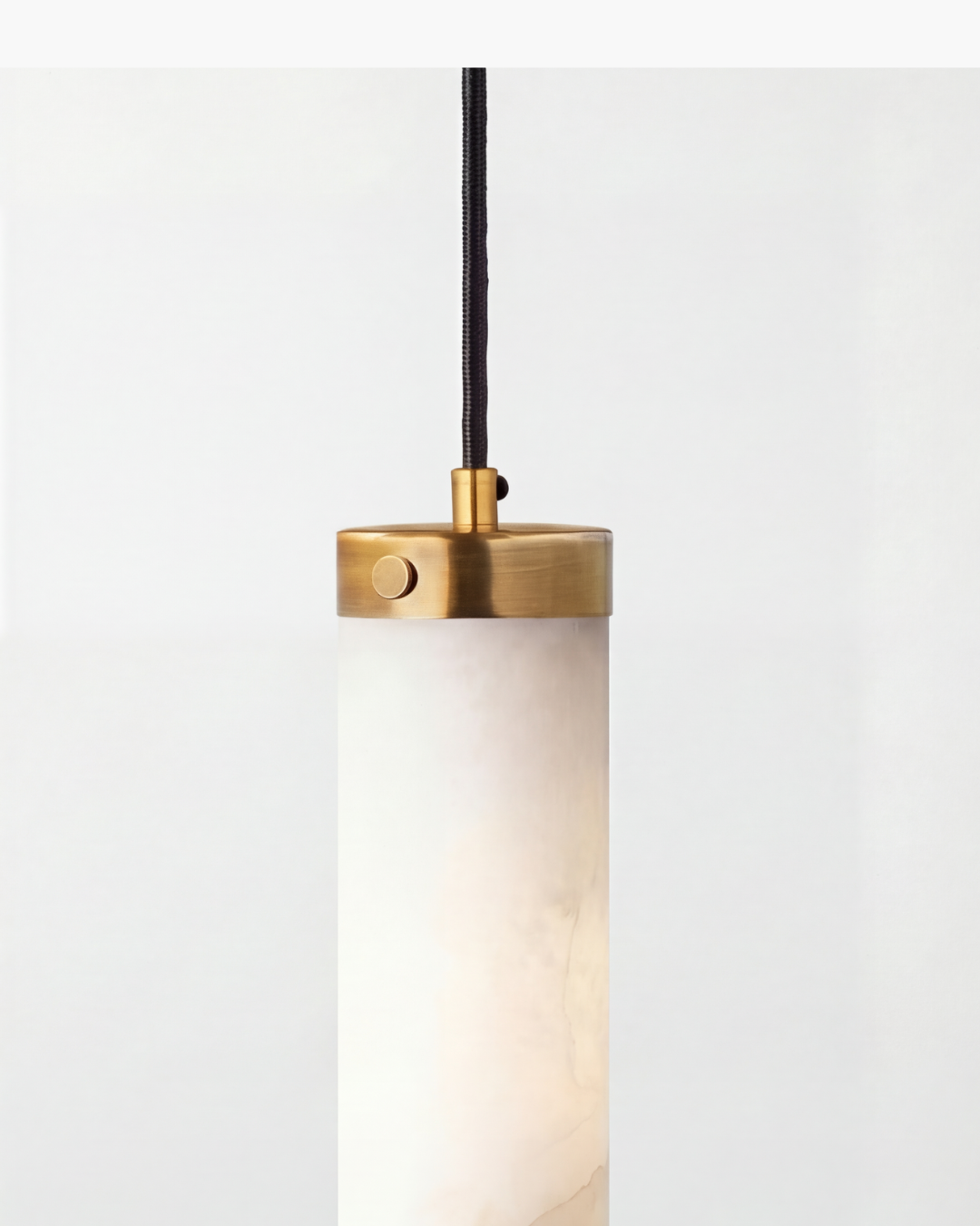 Modern pendant light with brass fixture on a white background