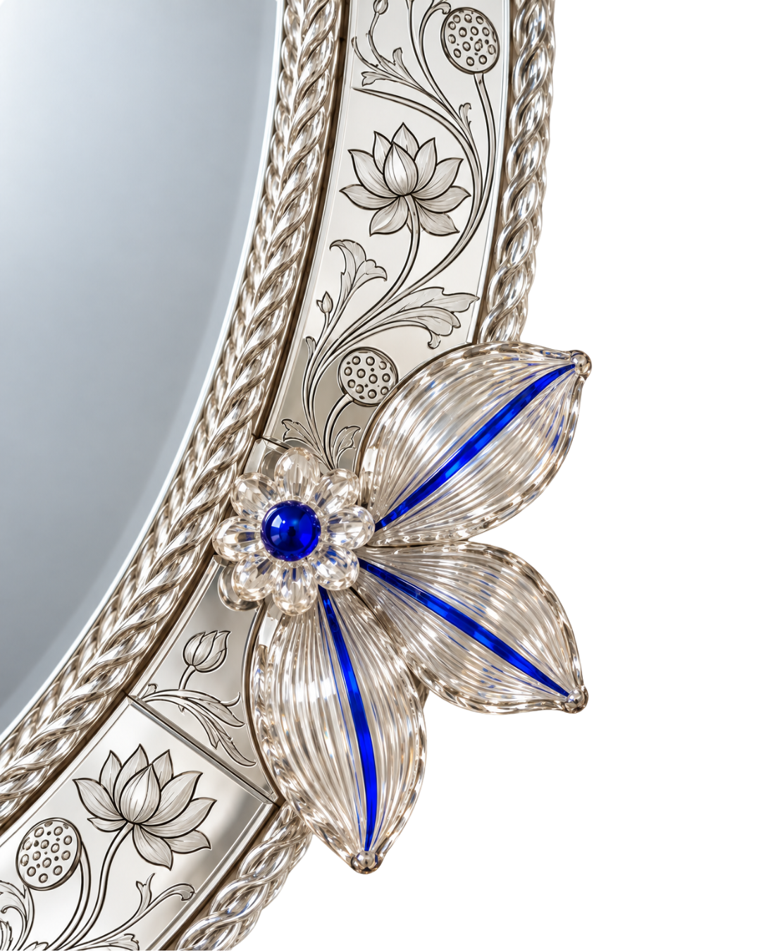 Close-up of an ornate silver mirror frame featuring a floral design with a blue gemstone center and a flower motif made of clear rhinestones and blue enamel.