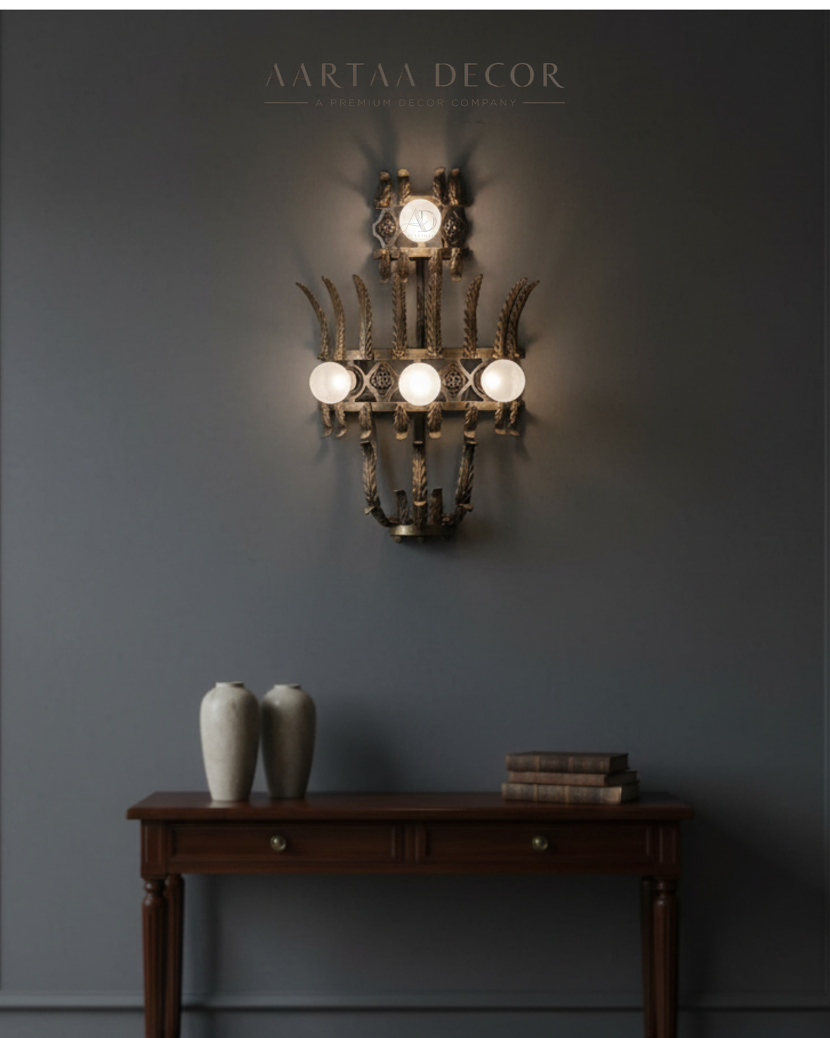 Decorative wall sconce with three lights on a dark gray wall, featuring Aartaa Decor branding.