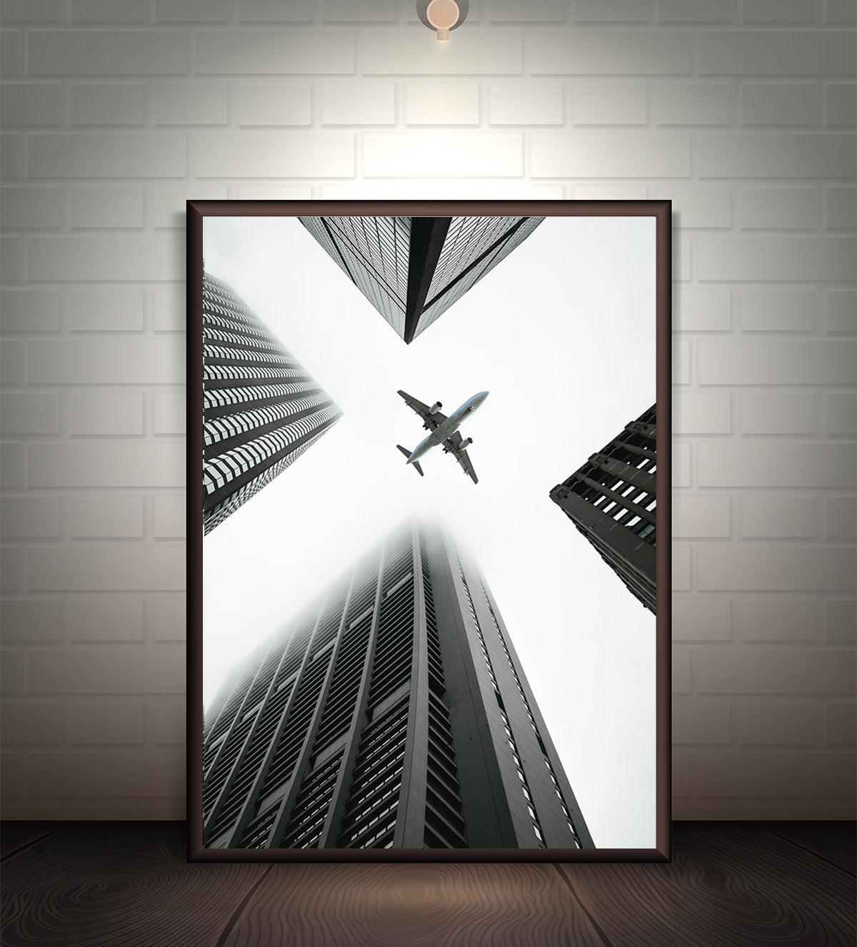 Modern black-and-white artwork of a plane flying between towering skyscrapers, symbolizing ambition and urban energy. Ideal for contemporary and industrial interiors, available in various sizes.