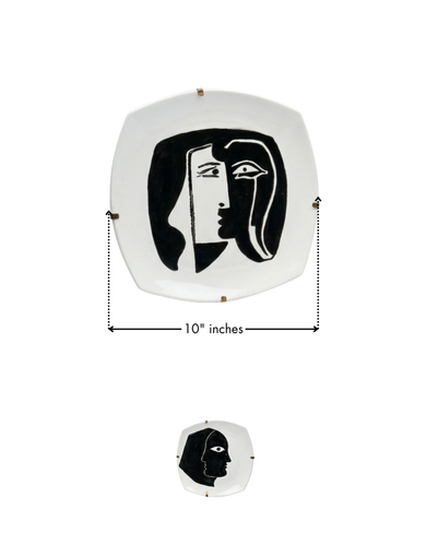 Decorative wall art with a black and white face design on a white background, showing measurements.